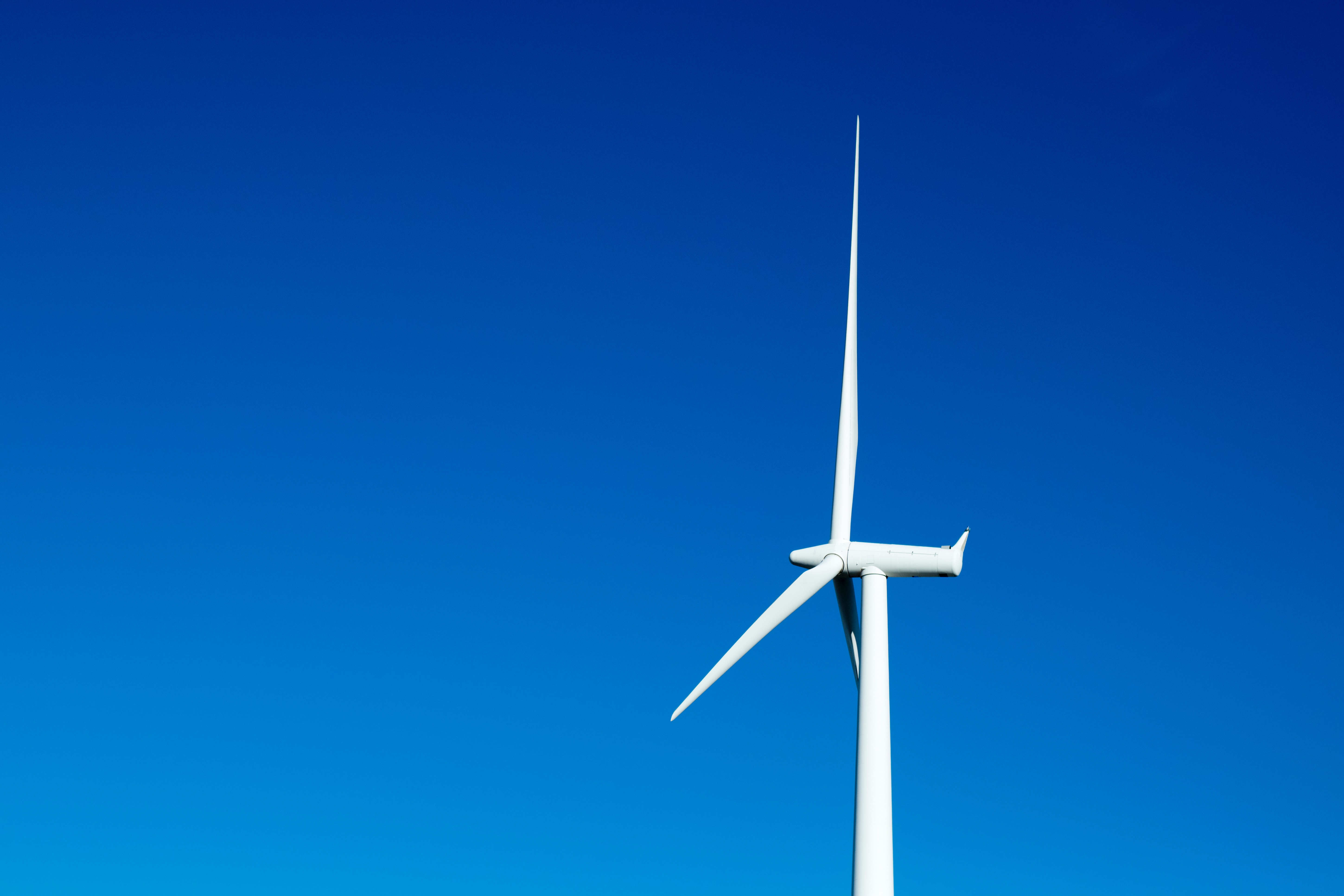 A photo of the turbine of a windmill at an offshore windfarm, credit to Brady Bellini from Unsplash