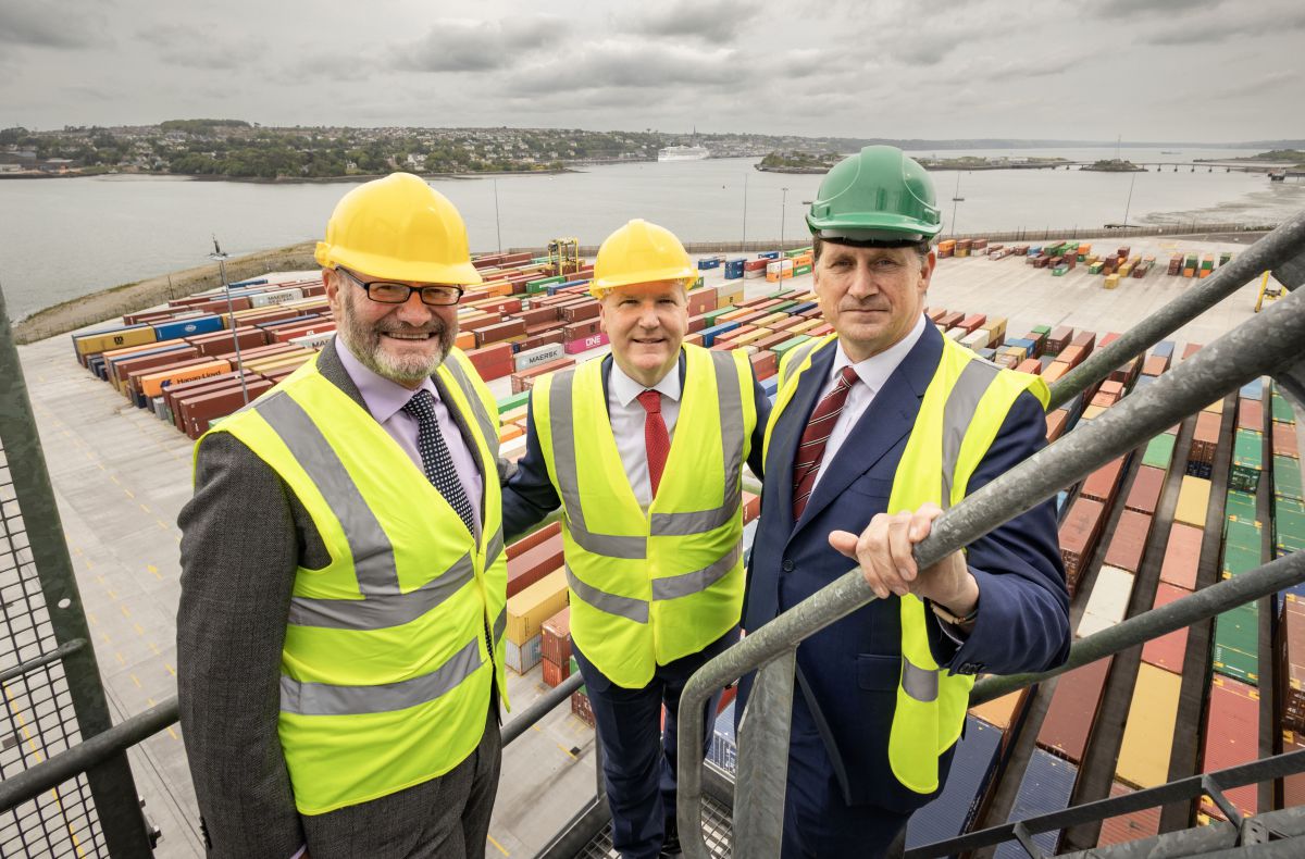 Three men, including TD Eamon Ryan, Michael McGrath TD, stand at Port of Cork