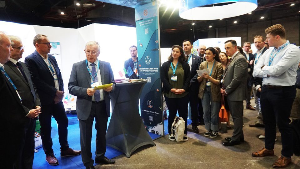 Individuals stand around each other at a conference