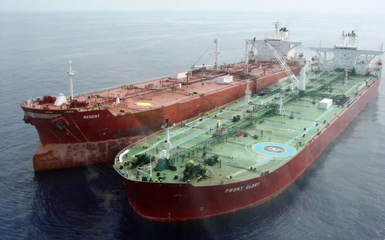 Two large cargo ships docked side by side on calm ocean water