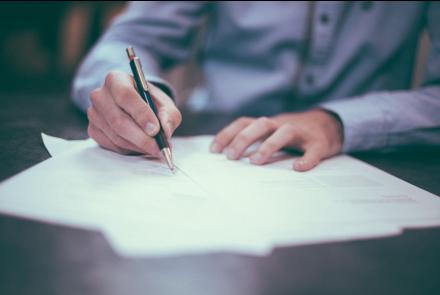 A photo by photographer Scott Graham of a person's hands writing on a piece of paper