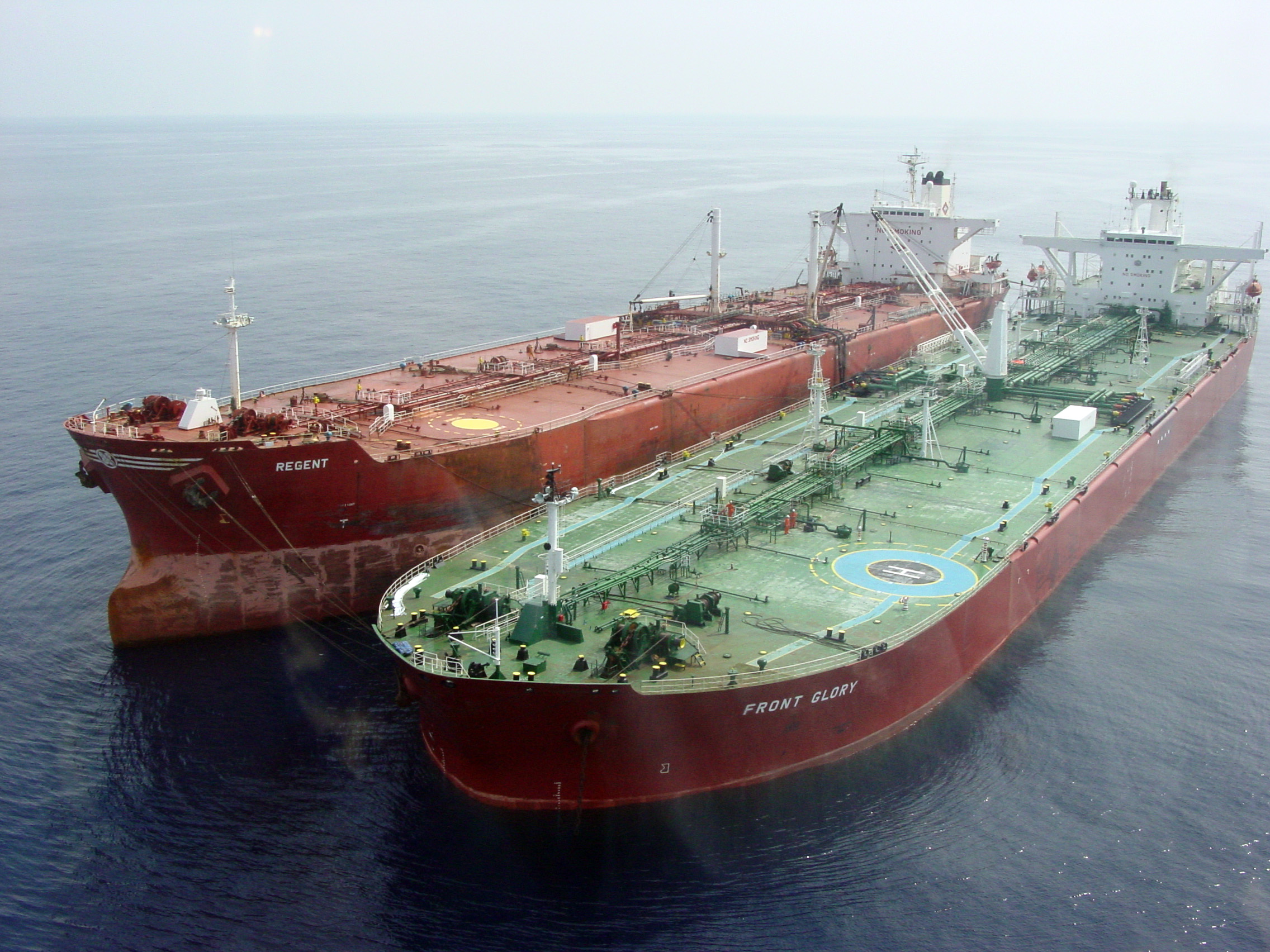 Two large cargo ships docked side by side on calm ocean water